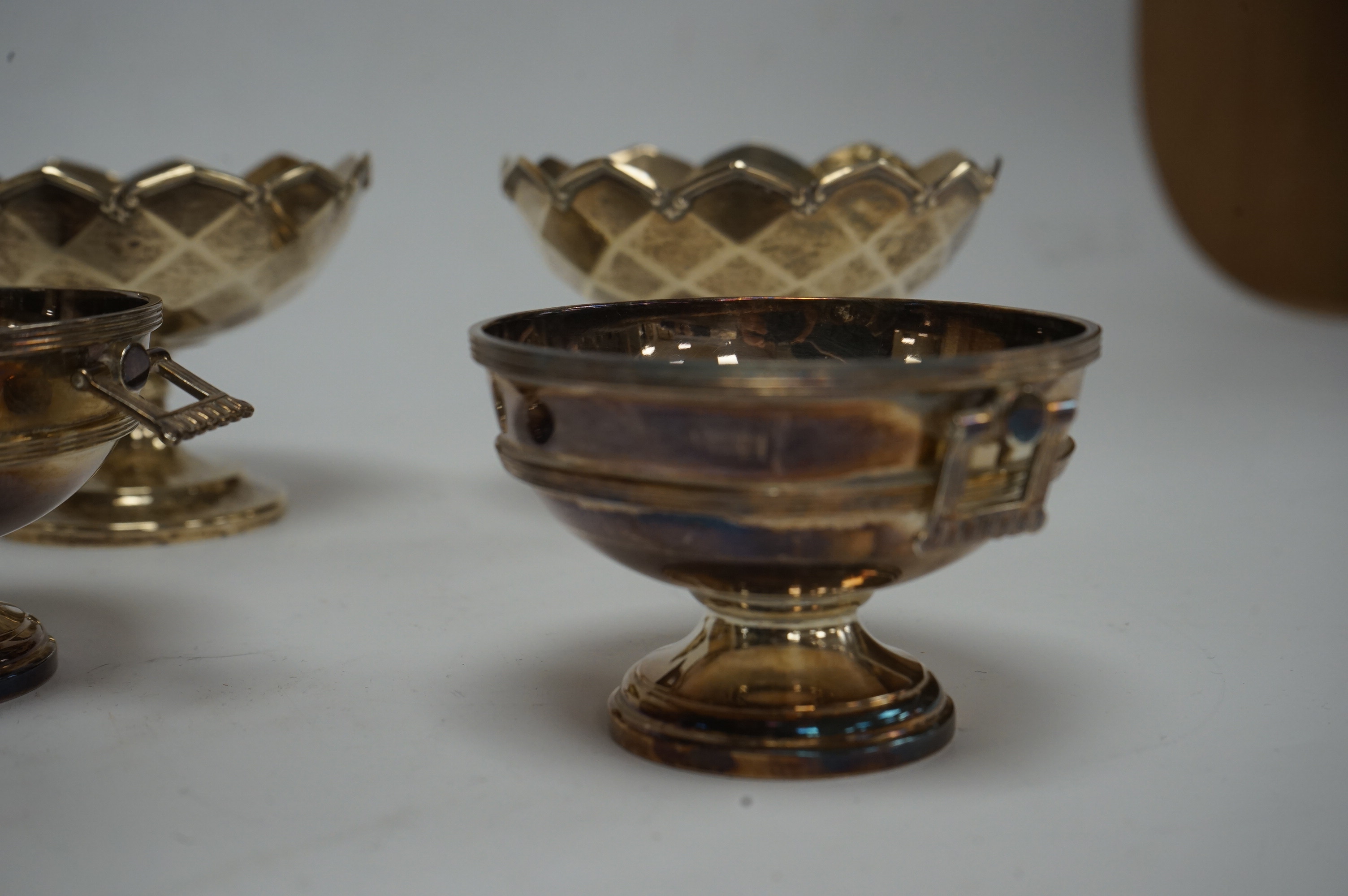 A pair of Elizabeth II silver two handled circular pedestal salts, by Walker & Hall, Sheffield, 1964, diameter 78mm, together with a small pair of George V silver pedestal bowls, Mappin & Webb, Birmingham, 1928, 10.3oz.